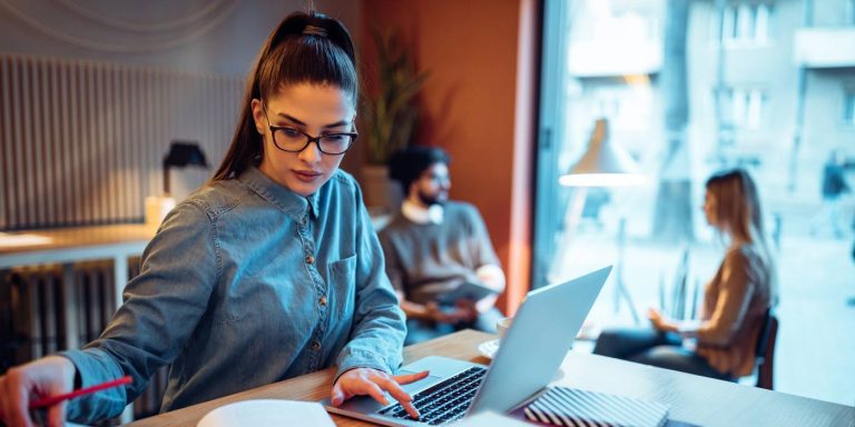 Estudiante trabajando en una laptop en el extranjero, guía para estudiar y trabajar fuera del país en 2024